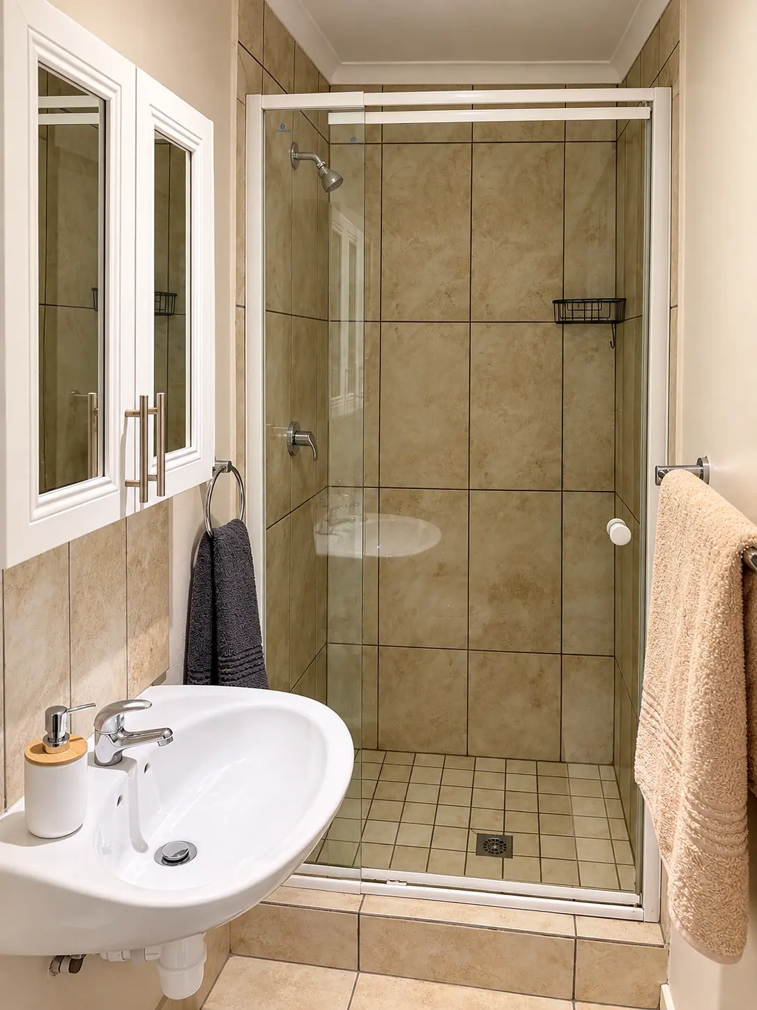 Clean bathroom with glass shower and fresh towels