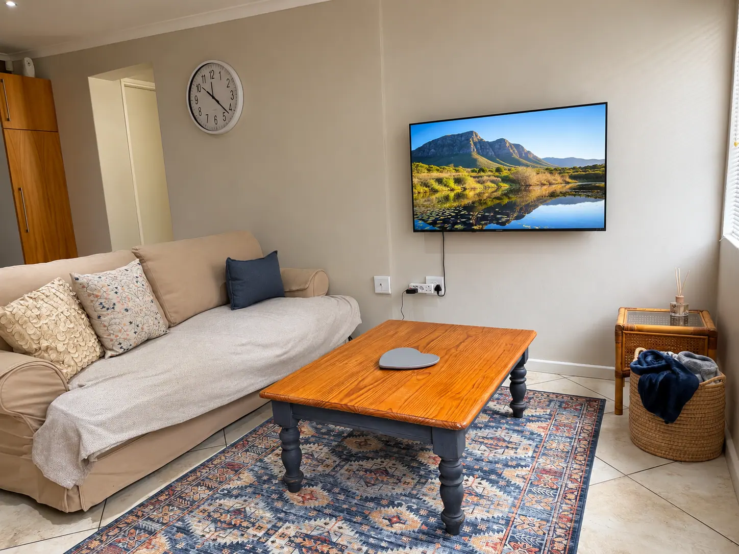 Lounge with sofa, patterned rug, and wall-mounted television
